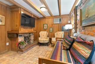 Level one efficiency suite sitting room with fireplace and historic wood paneling