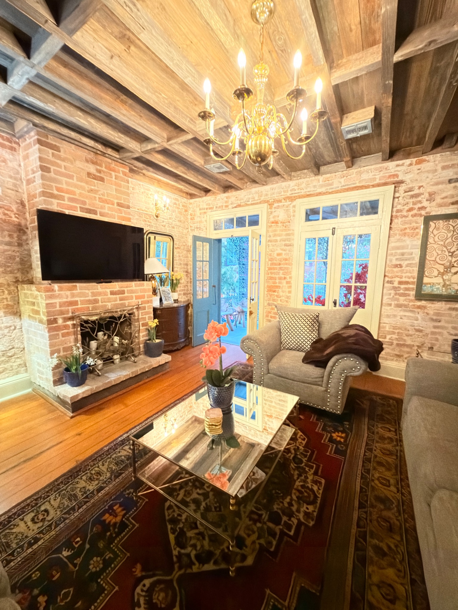Living room fireplace beneath historic reclaimed cypress ceiling